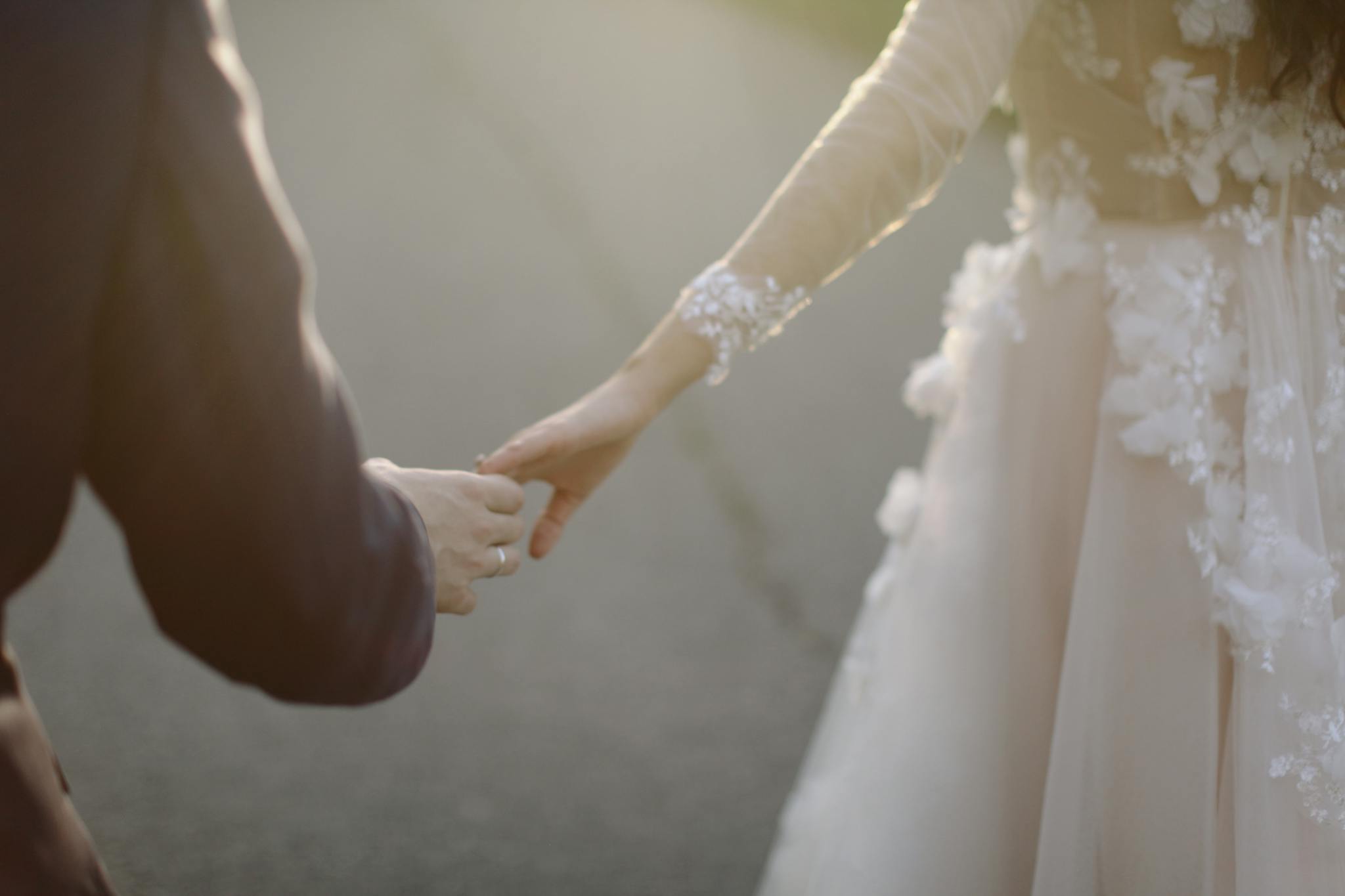 A tender moment captured of a bride and groom holding hands, symbolizing love and togetherness.