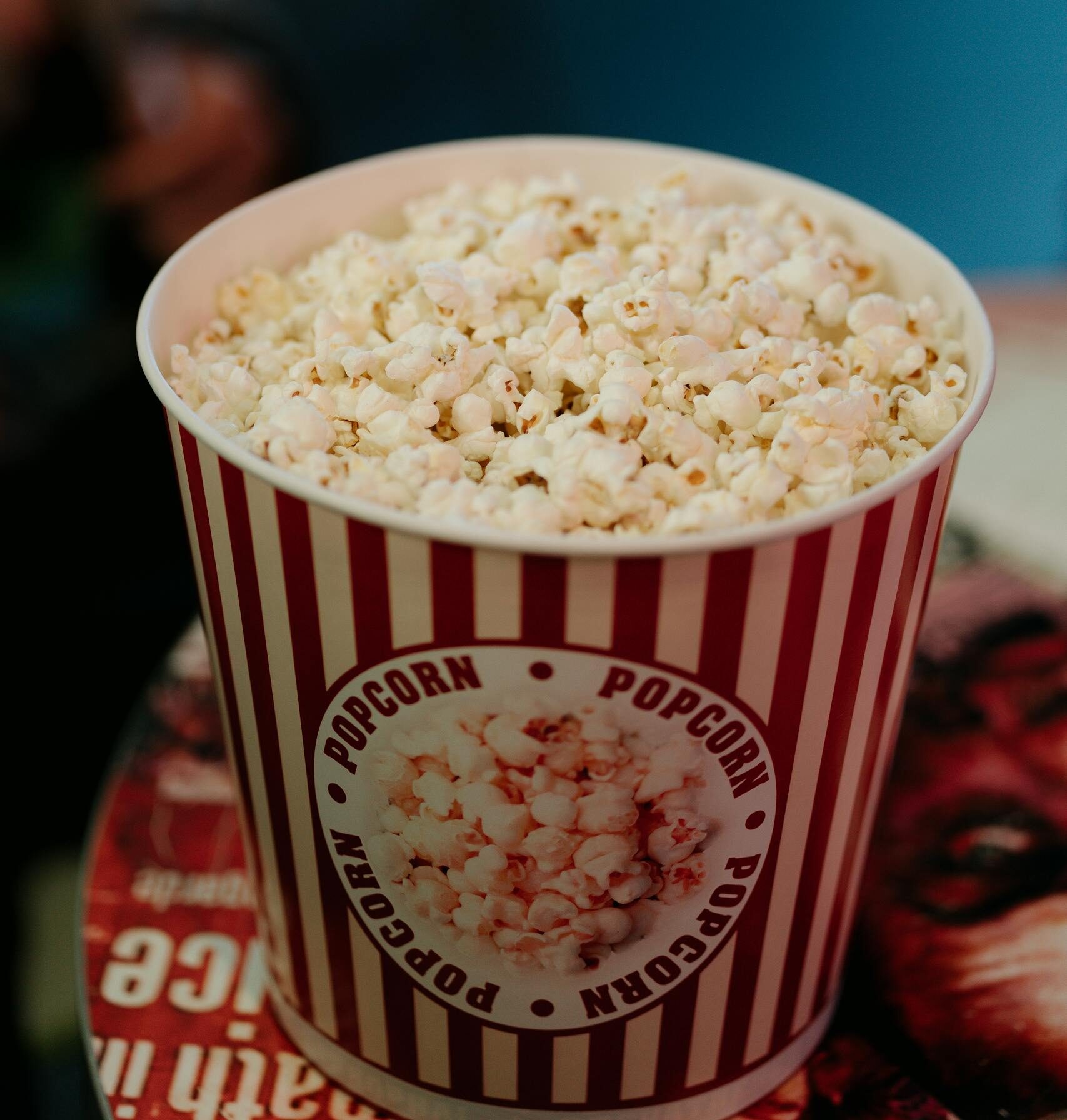 Delicious popcorn in a classic red and white bucket, perfect for movie nights.