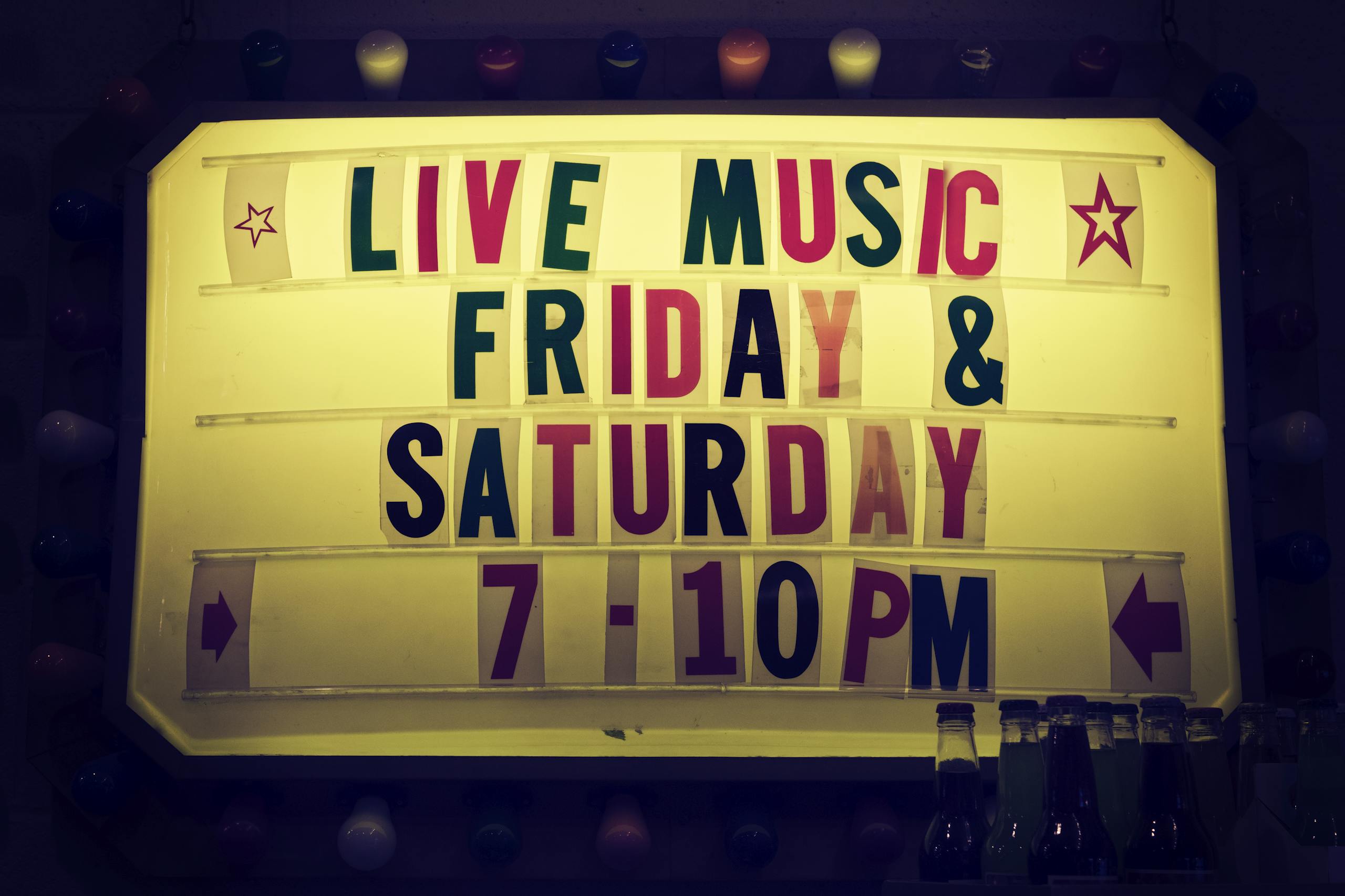 Illuminated vintage marquee promoting live music nights on Friday and Saturday.